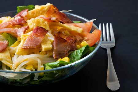 glass bowl with exquisite salad made with bacon and omeletteの写真素材