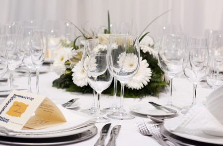 table set for wedding celebration with glass and flowersの写真素材