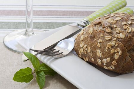 wholegrain bread on white tray whit knife and fork