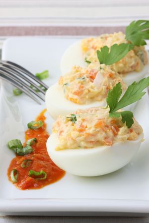 boiled egg with potato and carrot salad on white trayの写真素材