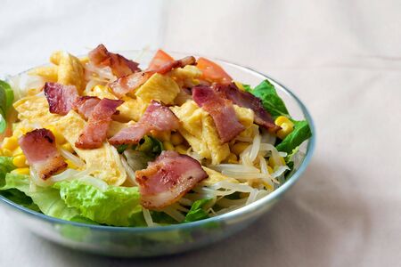 bowl of salad with bacon and omeletteの写真素材