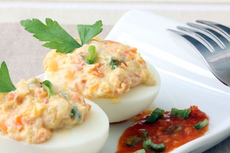 boiled egg filled with potato salad and tomato sauceの写真素材