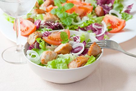 white platter of salad with green lettuce and chickenの写真素材