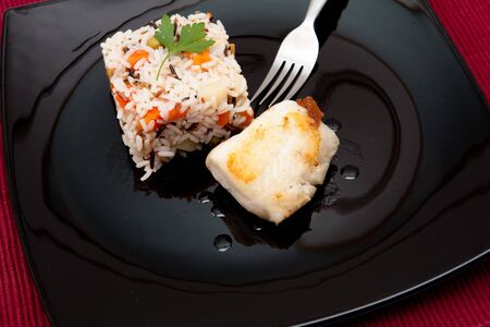 asian rice salad on a bowl with vegetables and fishの写真素材