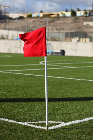 red corner flag on green football fieldの写真素材