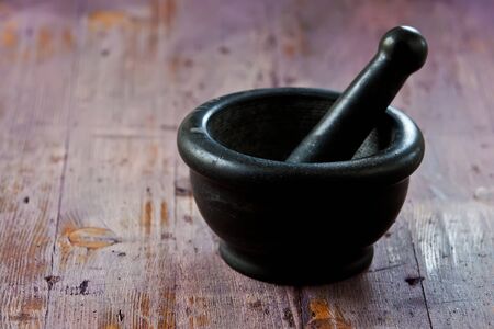 old black mortar and pestle on wooden backgroundの写真素材