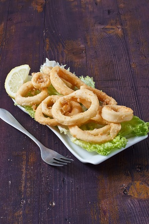 deep fried calamari with lettuce and lemonの写真素材