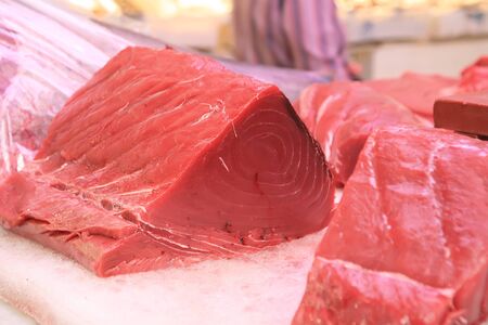 a big slice of fresh raw tuna on fishmongerの写真素材