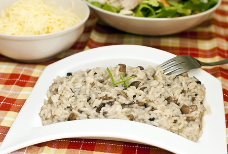 Risotto with mushrooms on white tray and forkの写真素材