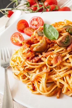 fine spaghetti with tomato bacon and cheese with basil leavesの写真素材