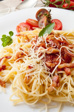 fine spaghetti with tomato bacon and cheese with basil leavesの写真素材