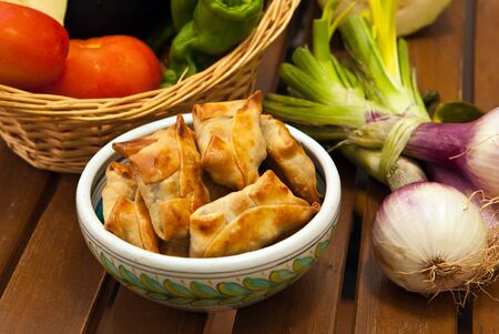 fried beef samosas with vegetables on basket