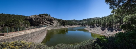 Dam between the mountains under a blue skyの写真素材