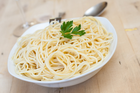 a plate with boiled spaghetti with parsley and olive oilの写真素材