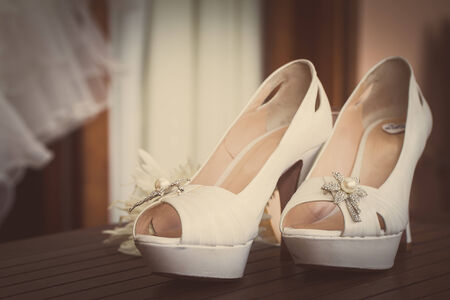 a pair of wedding shoes on wooden tableの写真素材