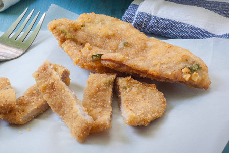 breaded chicken breast with french fries on tableの写真素材