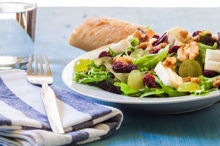 preparing a grape salad with cheese and nuts and red fruitsの写真素材