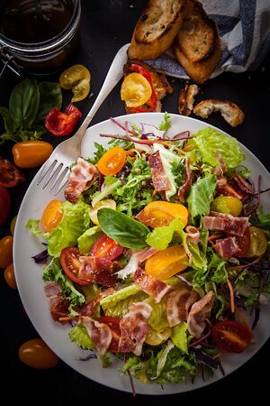 fresh salad with different lettuce types and tomatoesの写真素材