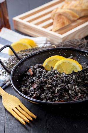 seafood risotto with black calamari ink on potの写真素材