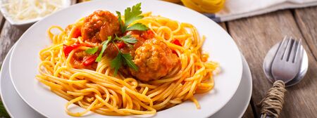 pasta with meatballs and parsley with tomato sauce on white plateの写真素材