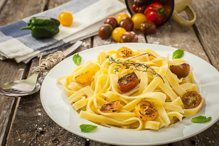homemade italian tagliatelle with tomato and herbsの写真素材