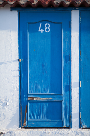 blue doors with number on white wallの写真素材