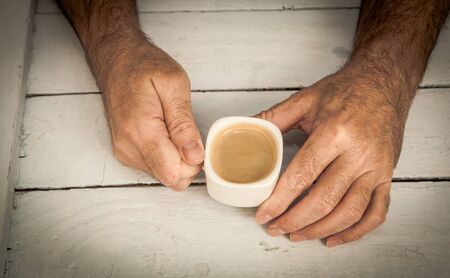 man holding a cup of coffe with vintage process