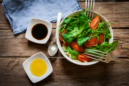 fresh mix of lettuce salad with tomato with seasoning oilの写真素材