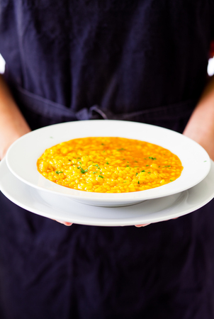 waitress serving a spanish seafood  paella dishの写真素材