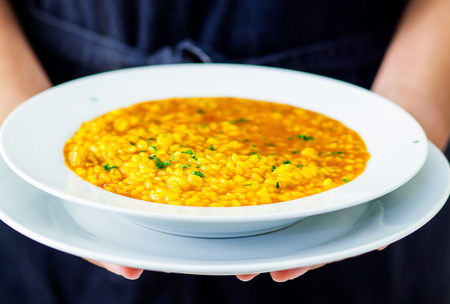 waitress serving a spanish seafood  paella dishの写真素材