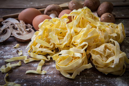 Fresh egg tagliatelle italian homemade pasta on wooden boardの写真素材