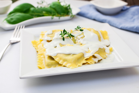 ravioli stuffed with ricotta and spinach with cheese sauceの写真素材