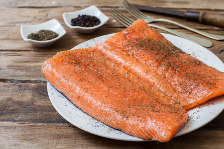 two raw salmon steak with fine herbs and saltの写真素材