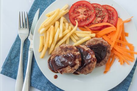 Homemade beef burger salisbury steak with vegetables and french fries