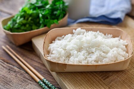 boiled rice on a bambu bowl with parsleyの写真素材