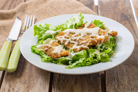 Fresh caesar salad with sauce on white plateの写真素材