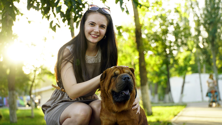 young woman walking in the park with a Shar-Pei.の写真素材