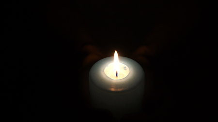 burning candle in the hands of womenの写真素材
