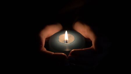 burning candle in the hands of womenの写真素材