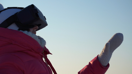 girl looks in the virtual reality goggles outdoors in winter.の写真素材