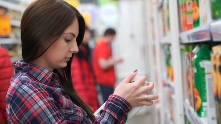 woman buys juice in supermarket or store.の写真素材
