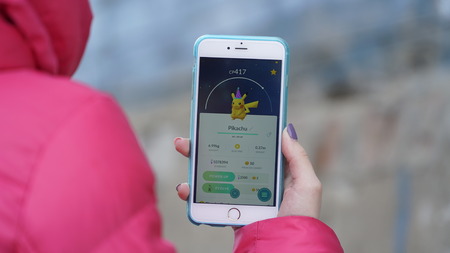 Samara, Russia - March 7, 2017: woman playing pokemon go on his iphone 6s Plus. pokemon go multiplayer game with elements of augmented reality.のeditorial素材