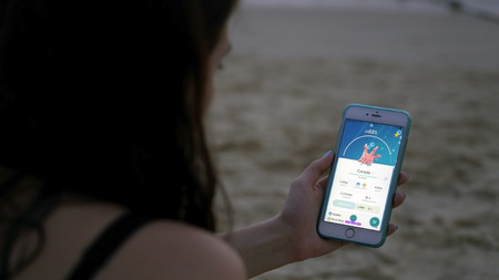 Phuket, Thailand - March 28, 2017: woman playing pokemon go on his iphone 6s Plus. pokemon go multiplayer game with elements of augmented reality. Corsola was caught.のeditorial素材