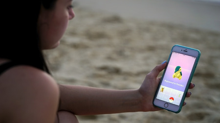 Phuket, Thailand - March 28, 2017: woman playing pokemon go on his iphone 6s Plus. pokemon go multiplayer game with elements of augmented reality. Cyndaquil was caught.のeditorial素材