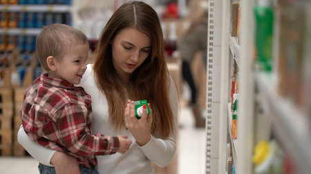 young mother and son buy water or juice in a store.の写真素材