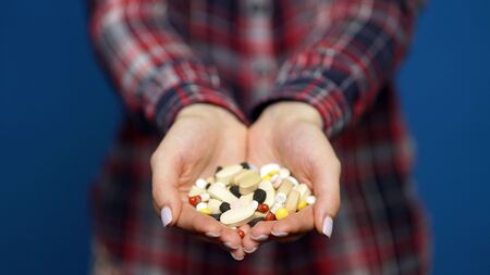 woman presenting a handful of pillsの写真素材