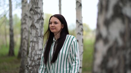 Girl walks in a birch grove on a spring day.の写真素材