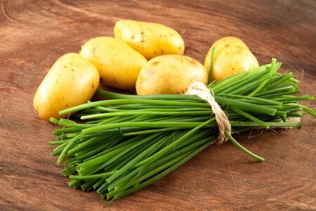 fresh potatoes and chives on woodの写真素材