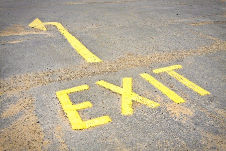 Yellow exit sign on a tarmac surfaceの写真素材