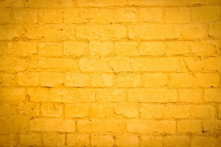 Vibrant yellow brick wall as a background image with vignetteの写真素材